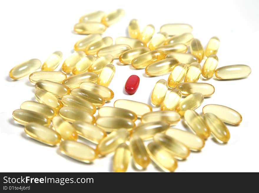 Clear gold pills on white with one red standout pill. Clear gold pills on white with one red standout pill