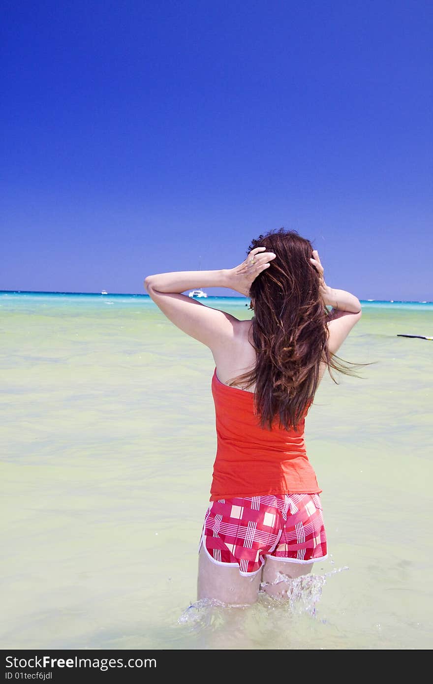 Latina woman going into the water in Mondello Sicily