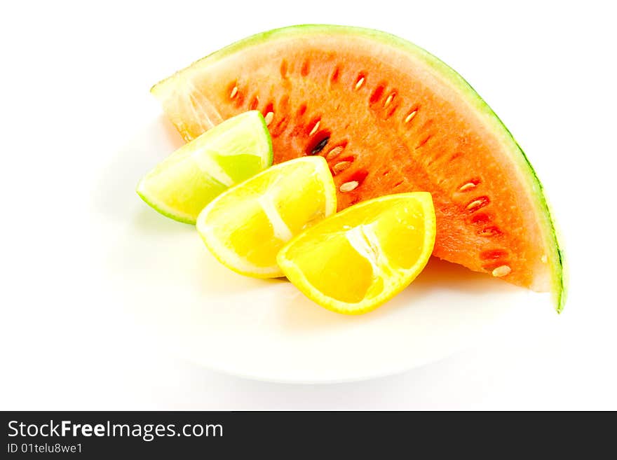 Lemon, lime and orange wedges with a slice of juciy watermelon on a white background. Lemon, lime and orange wedges with a slice of juciy watermelon on a white background