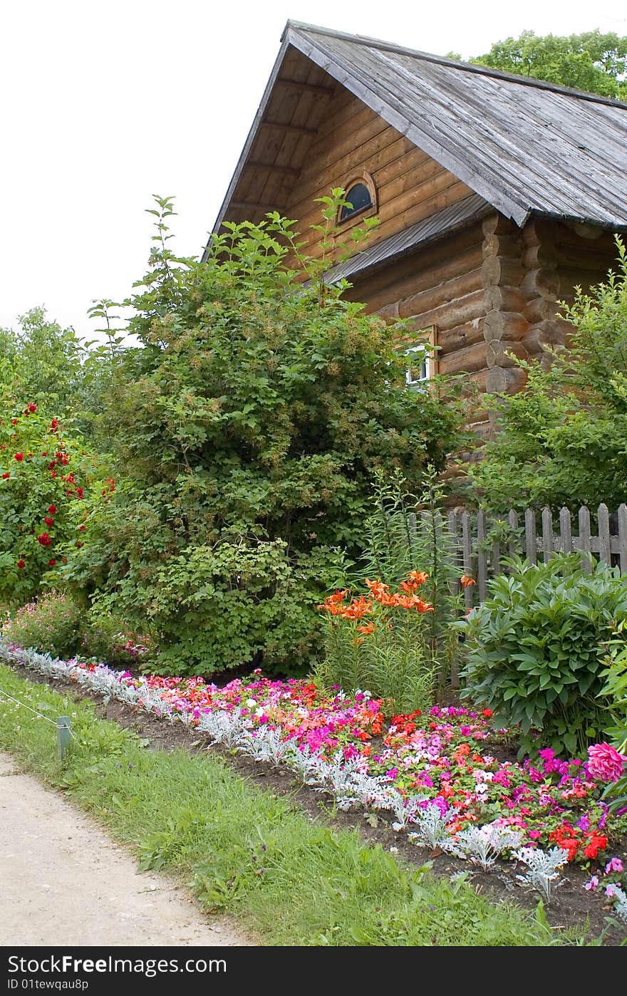 Wooden house with brushwood grass and flowers