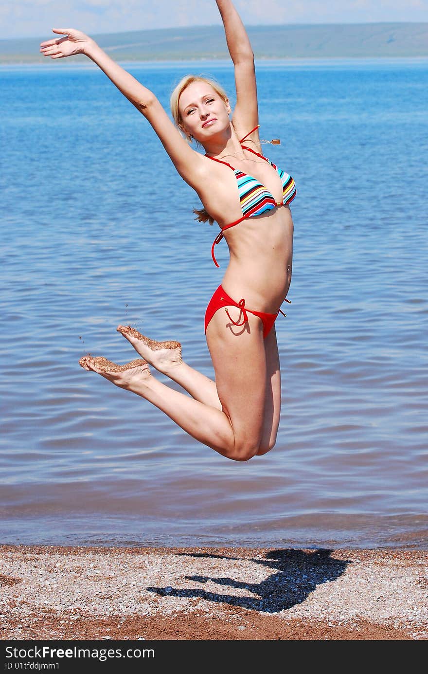 HAPPY YOUNG BEAUTIFUL WOMAN JUMP ON THE BEACH. HAPPY YOUNG BEAUTIFUL WOMAN JUMP ON THE BEACH