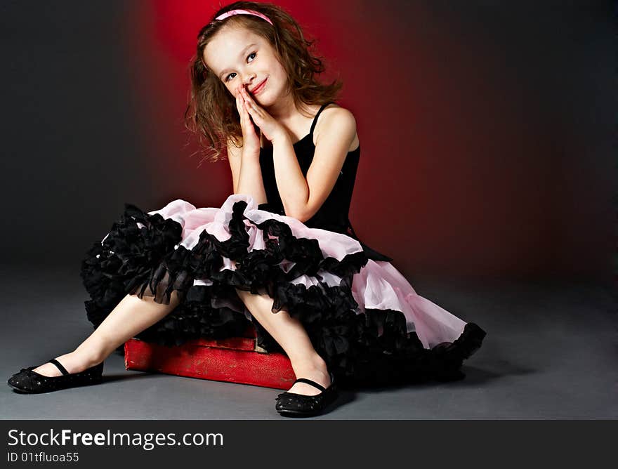 Cute little girl sitting in a old suitcase