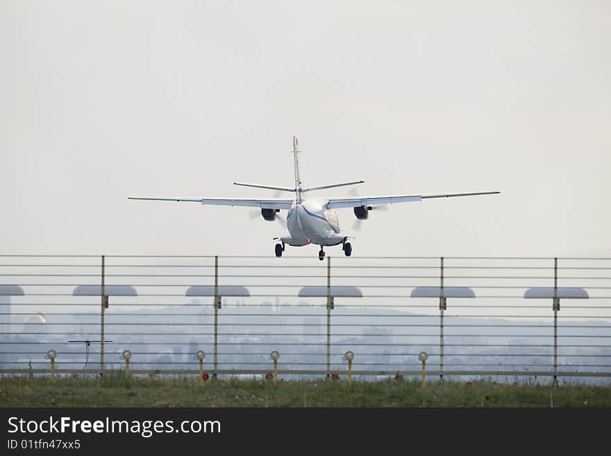 Plane approaching for landing over a fence. Plane approaching for landing over a fence