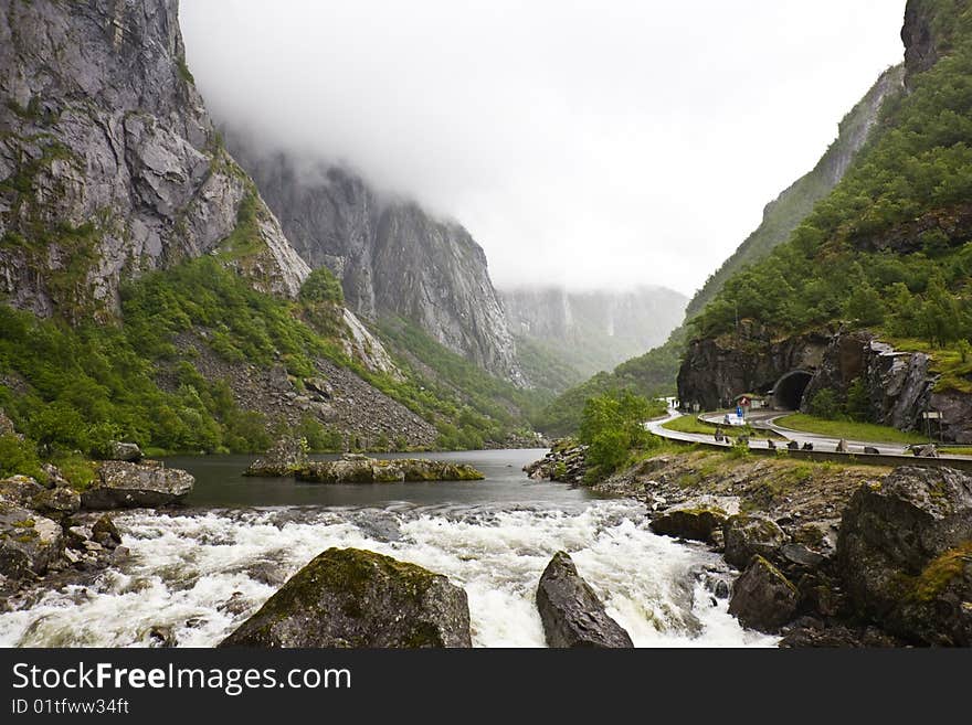 The cloud has hung in gorge over the mountain river