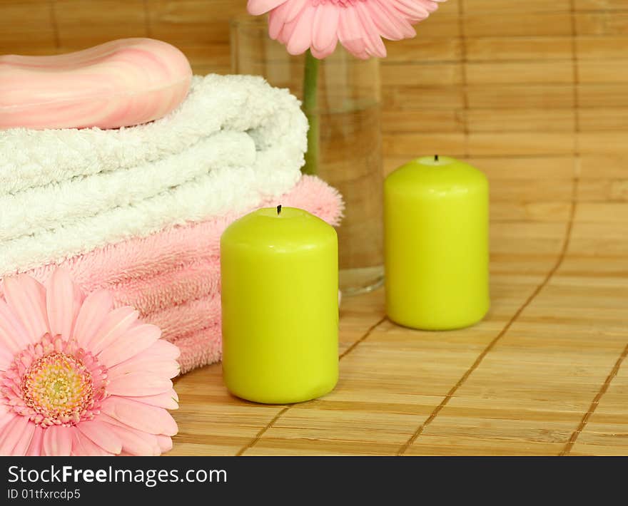 Spa concept. Towels, candles, soap and pink gerber.