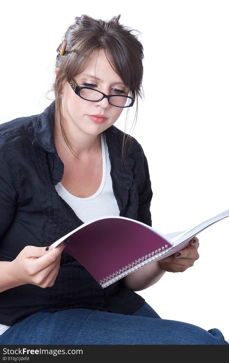 A young businesswoman in casual attire reviews her planner; isolated on a white background. A young businesswoman in casual attire reviews her planner; isolated on a white background.