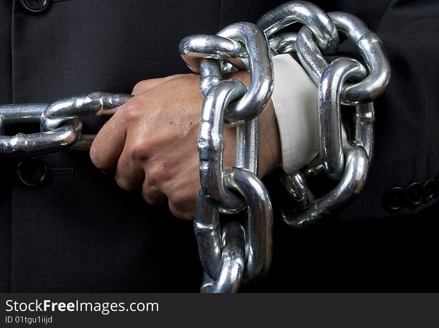 Businessman holding a heavy chain, isolated on black. Businessman holding a heavy chain, isolated on black