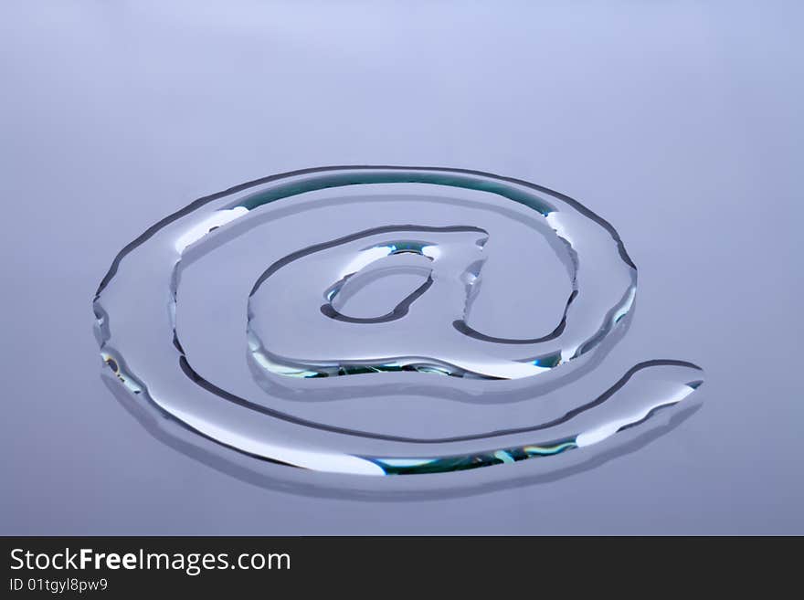 At symbol written in water on a glass plate