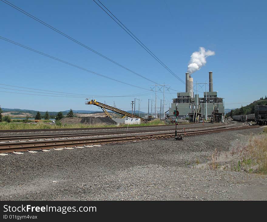 A modern two boiler coal fired powerplant in operation. Railroad tracks in the foreground are for the trains that provide this plant with thousands of tons of coal. A modern two boiler coal fired powerplant in operation. Railroad tracks in the foreground are for the trains that provide this plant with thousands of tons of coal.