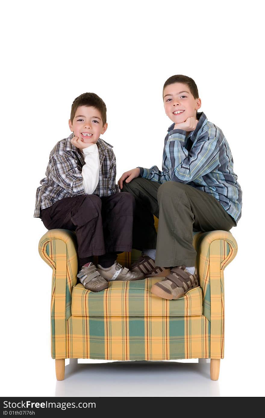 Two young happy smiling boys sitting on the back of the chair. Two young happy smiling boys sitting on the back of the chair