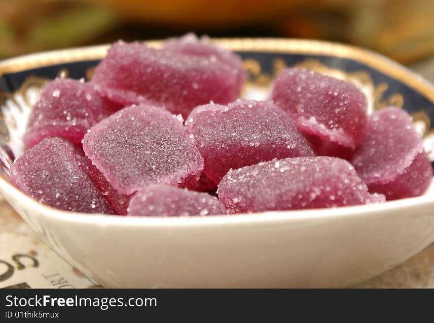 Fruit candy in a square plate with patterns on a white background