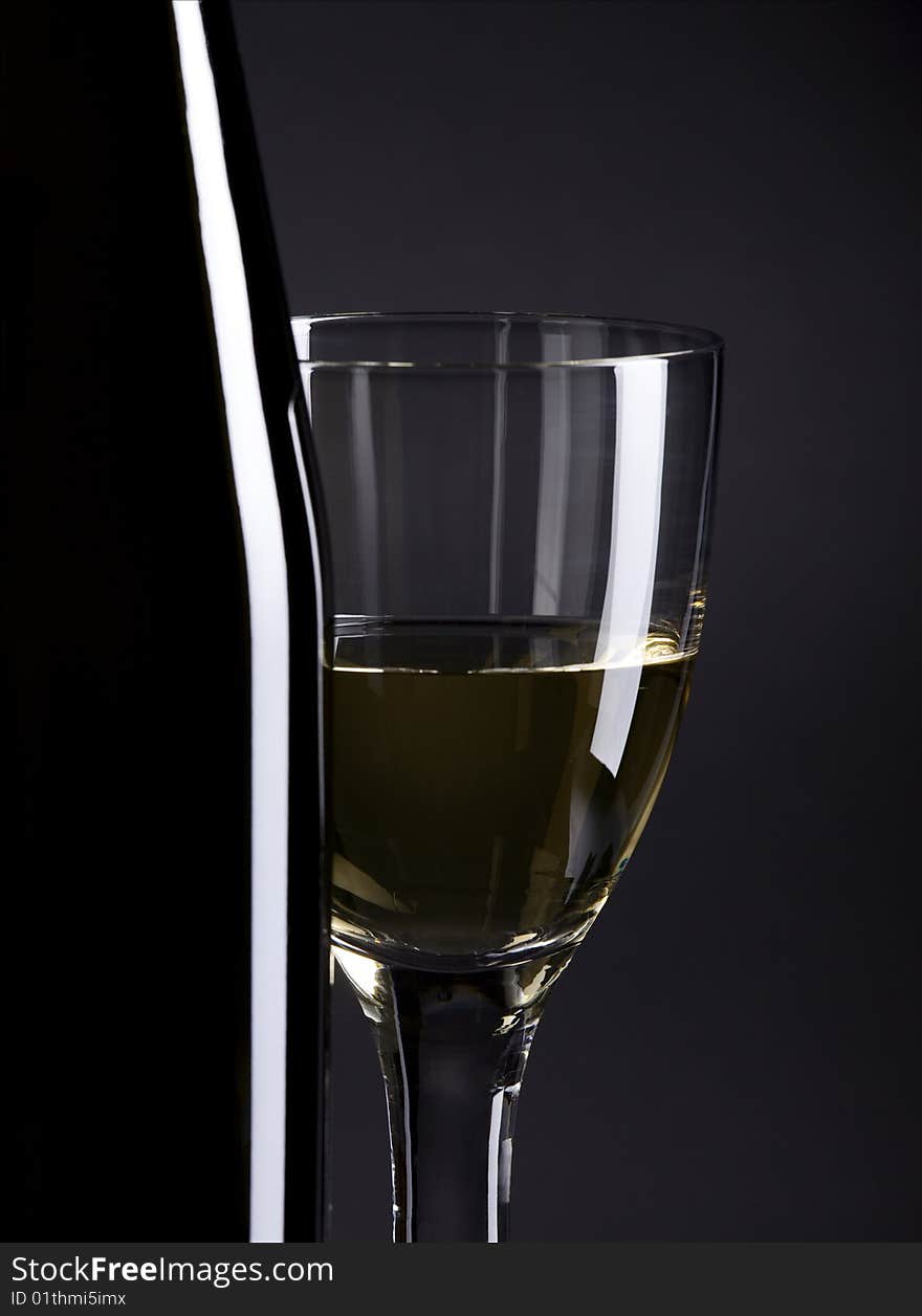 Wine bottle and glass, selective focus, focus on the glass