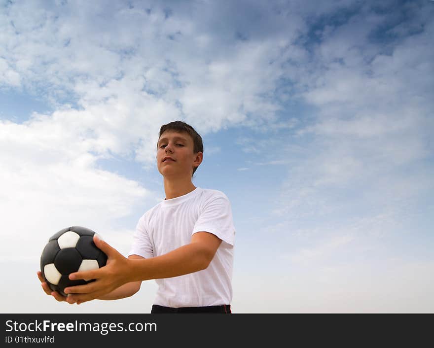 The hands of teenager holds a soccer ball