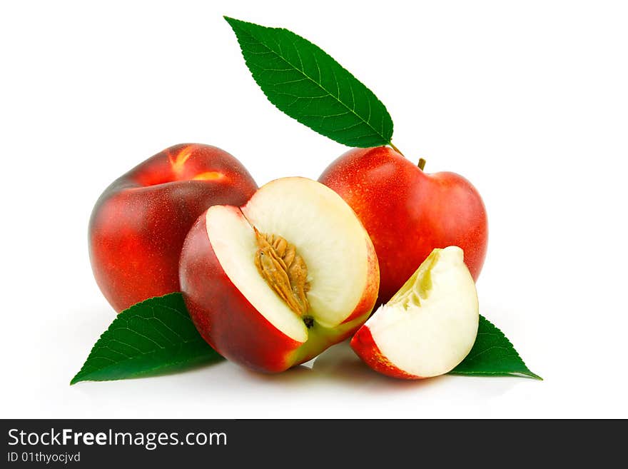 Ripe sliced peach (Nectarine) with green leafs isolated on white background