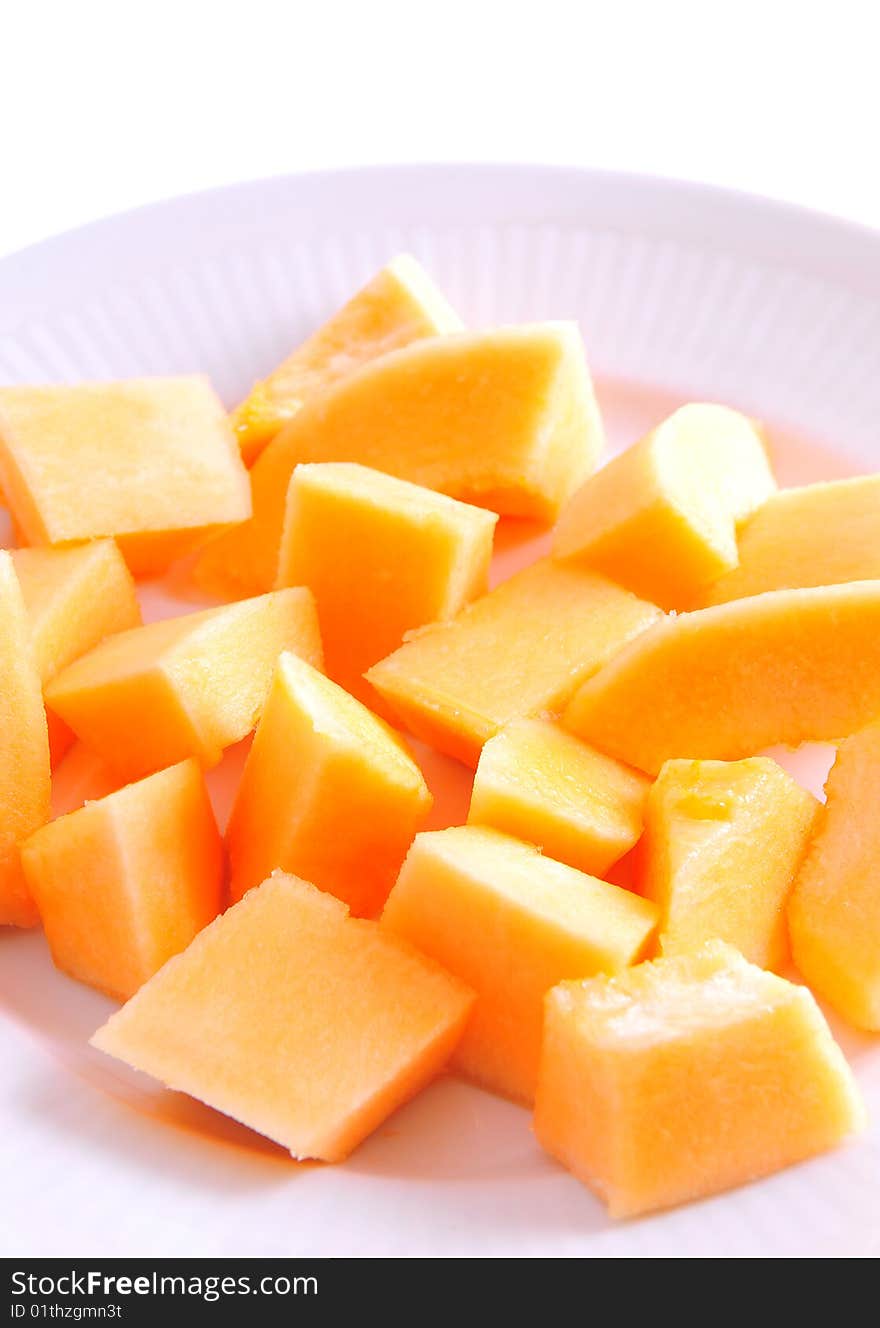 Juicy sliced melon on plate, isolated on white background.