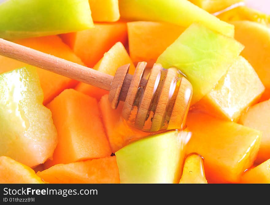 Juicy sliced melon on plate with honey