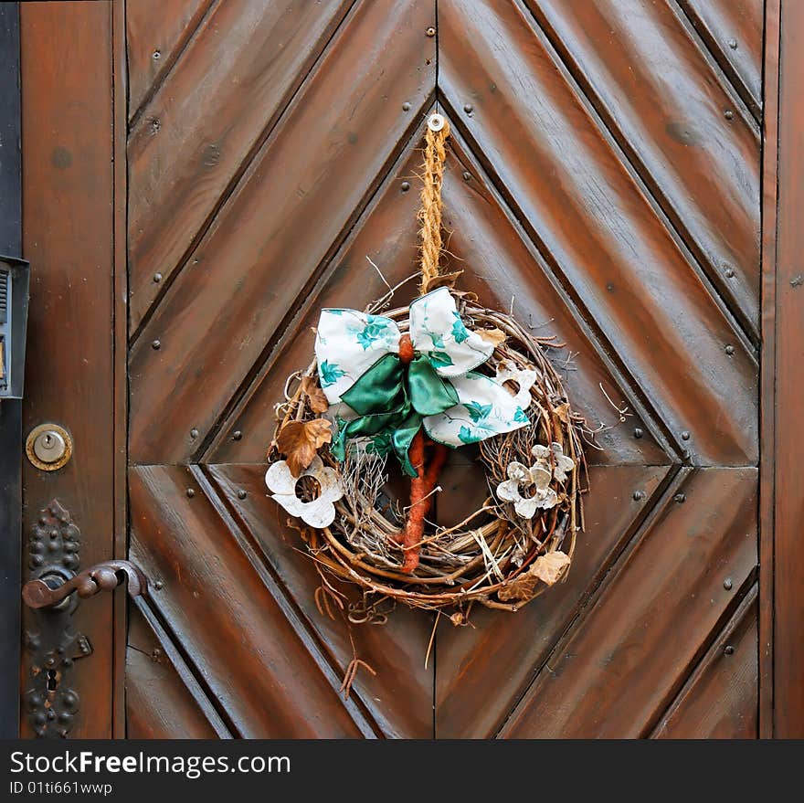 Dry old wreath on brown wooden door closeup