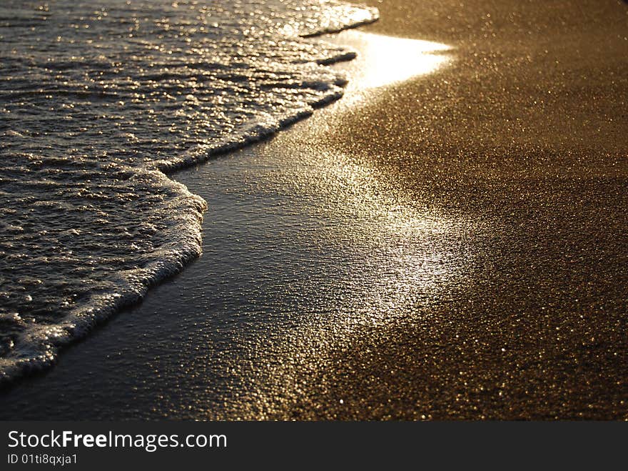 Sandy beach and sea waves during sunset. Sandy beach and sea waves during sunset