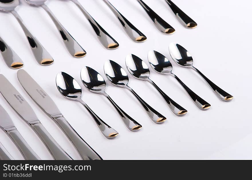 Row of spoons and forks on a white background