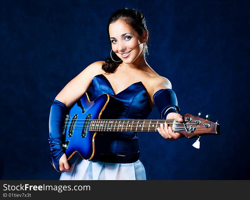 Portrait of a young brunette woman playing the guitar. Portrait of a young brunette woman playing the guitar