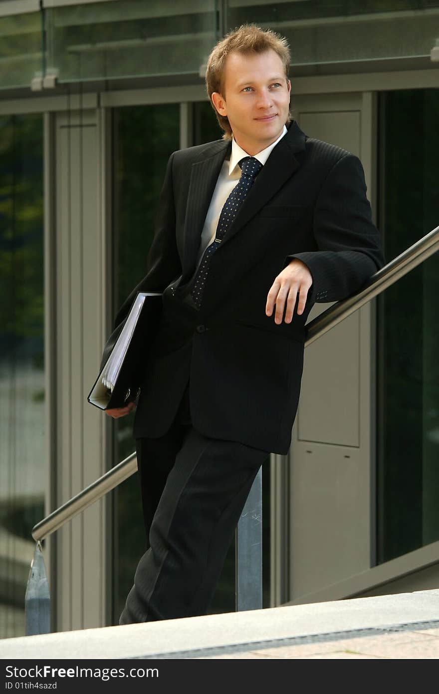 Happy businessman with folder relaxing in the sun