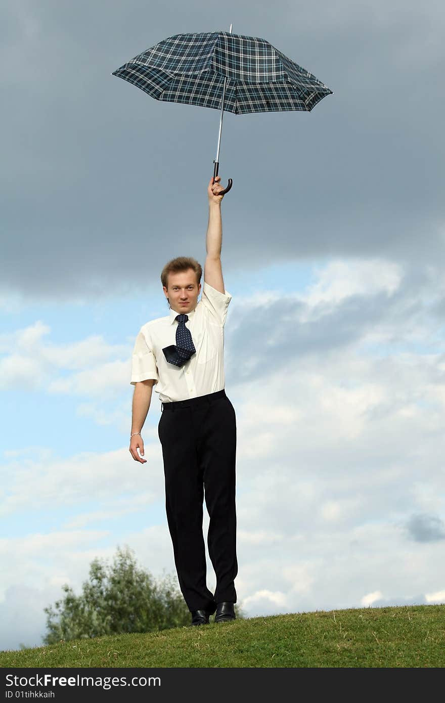 Businessman holding umbrella over head in a city park. Businessman holding umbrella over head in a city park