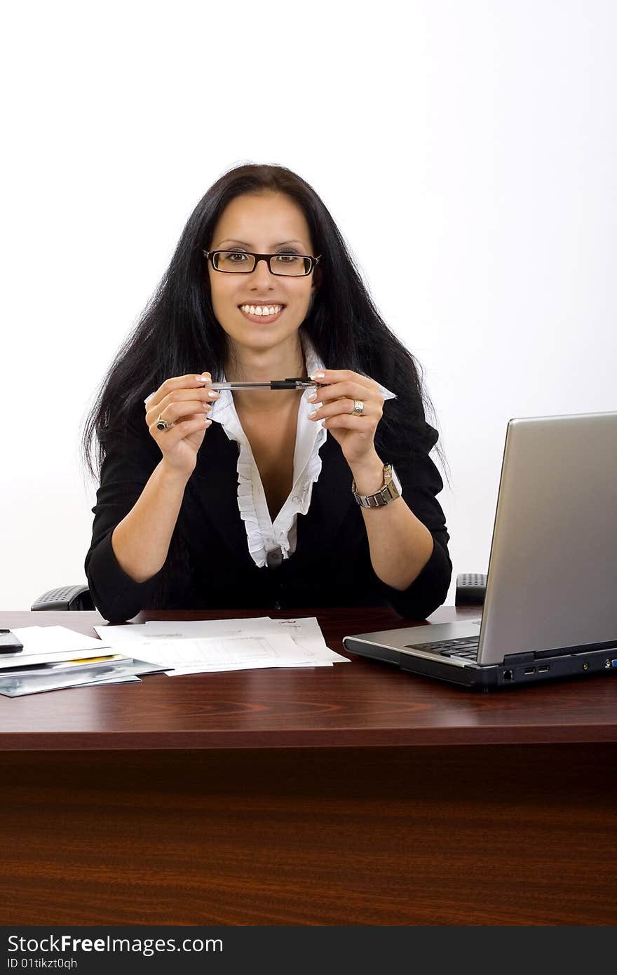 Attractive businesswoman on her desk holding a pen