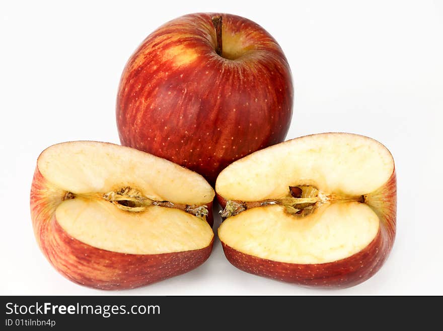 Two red apples, whole and cut on a white background