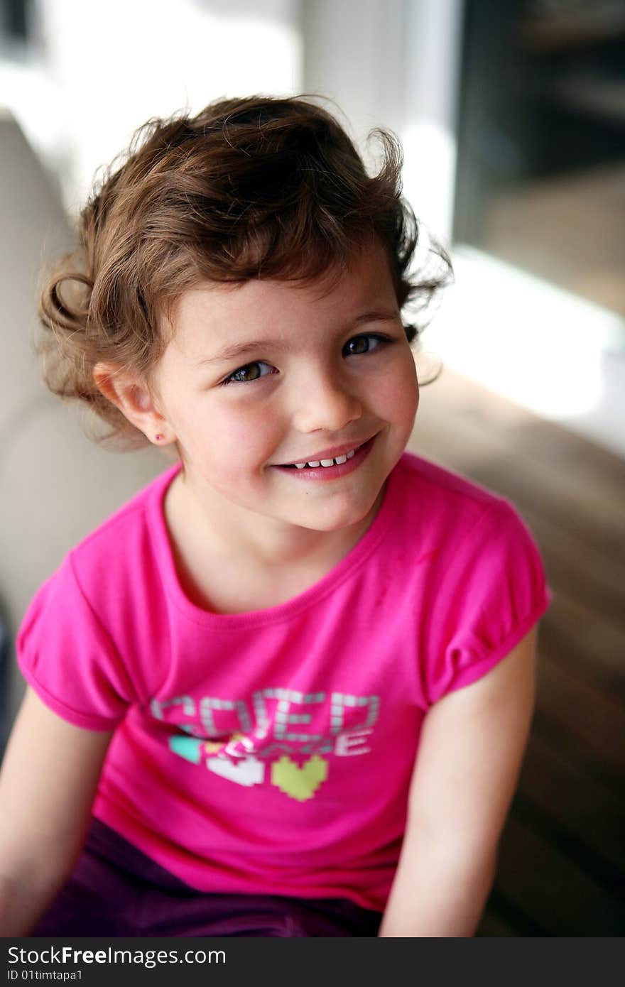 Happy girl sitting in front of house door