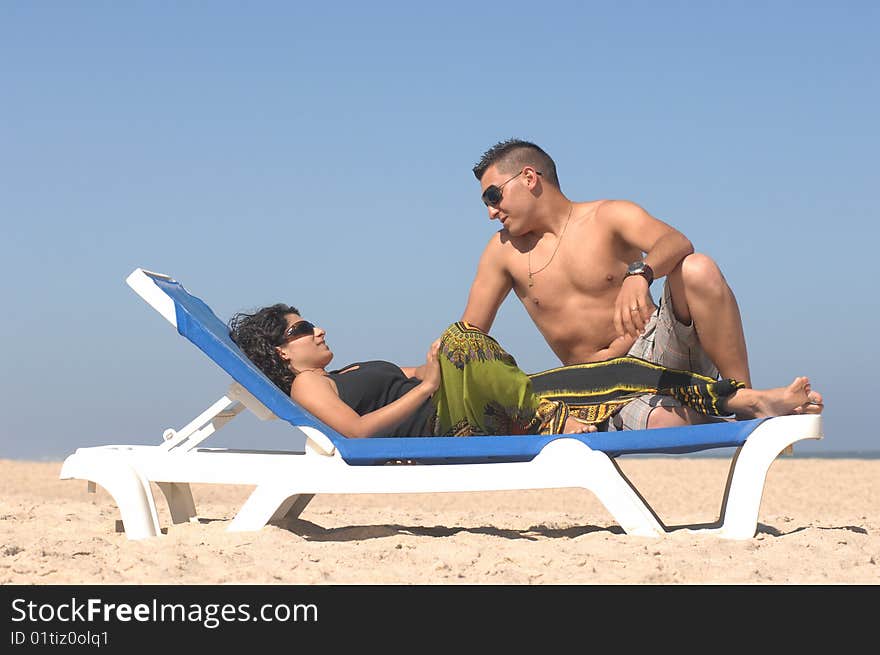 Attractive lovely couple relaxing on the beach. Attractive lovely couple relaxing on the beach