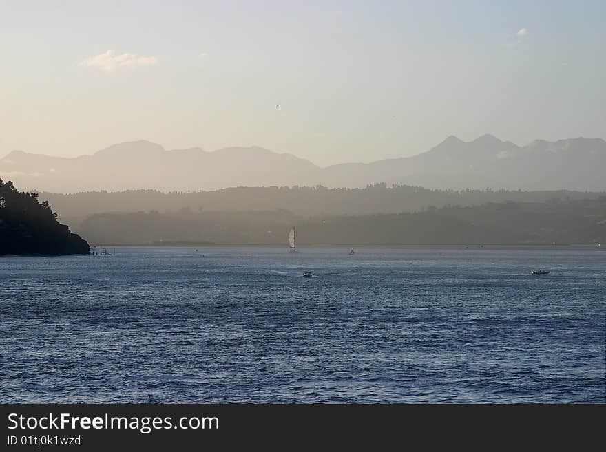 Yacht and motorboat in the Knysna estuary with mountains in the background