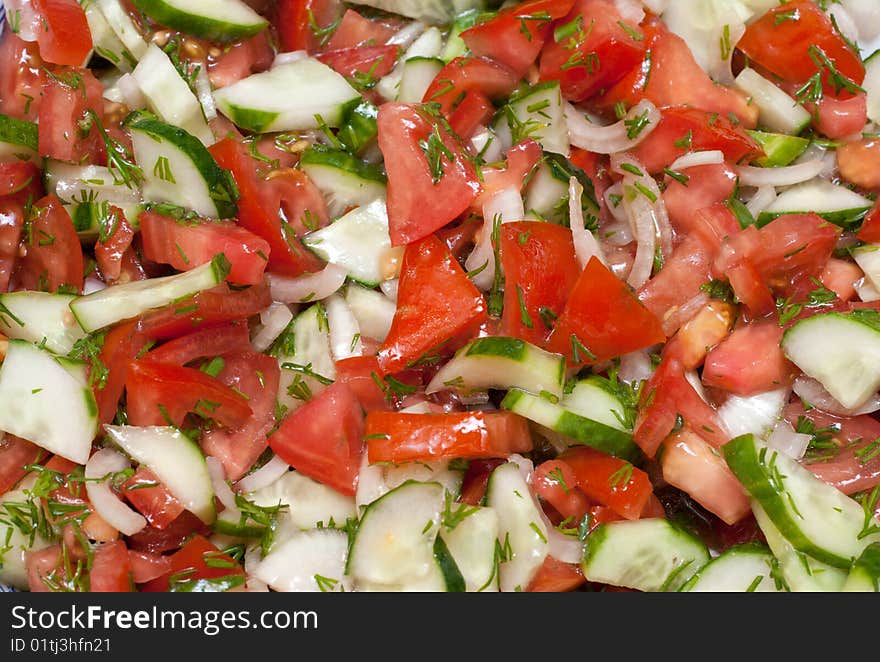 Appetizing salad from fresh tomato and cucumber in olive oil