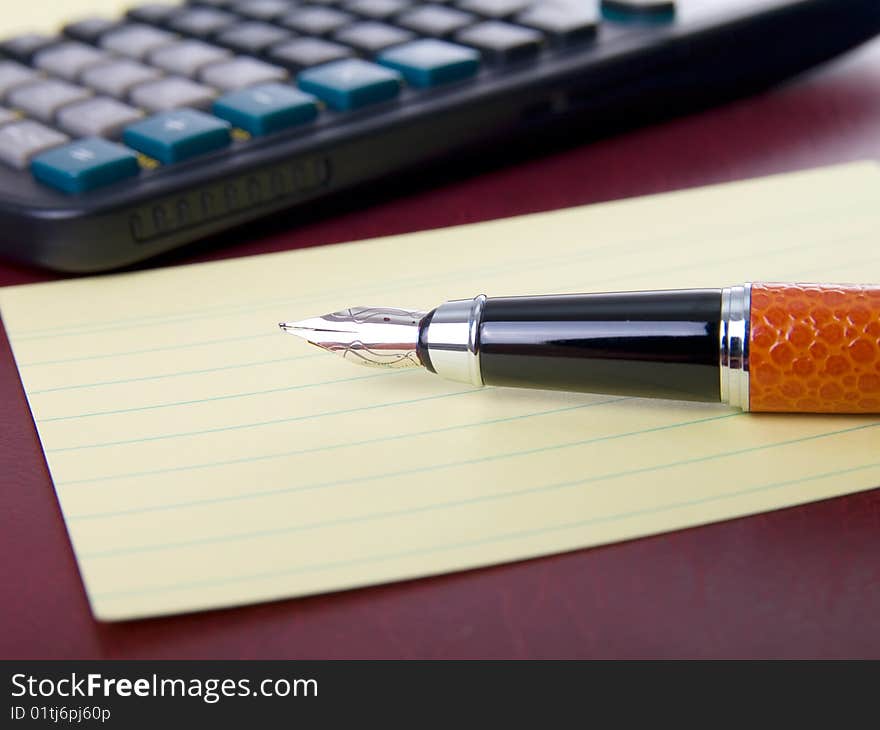 Office supplies: notebook, pen and calculator.