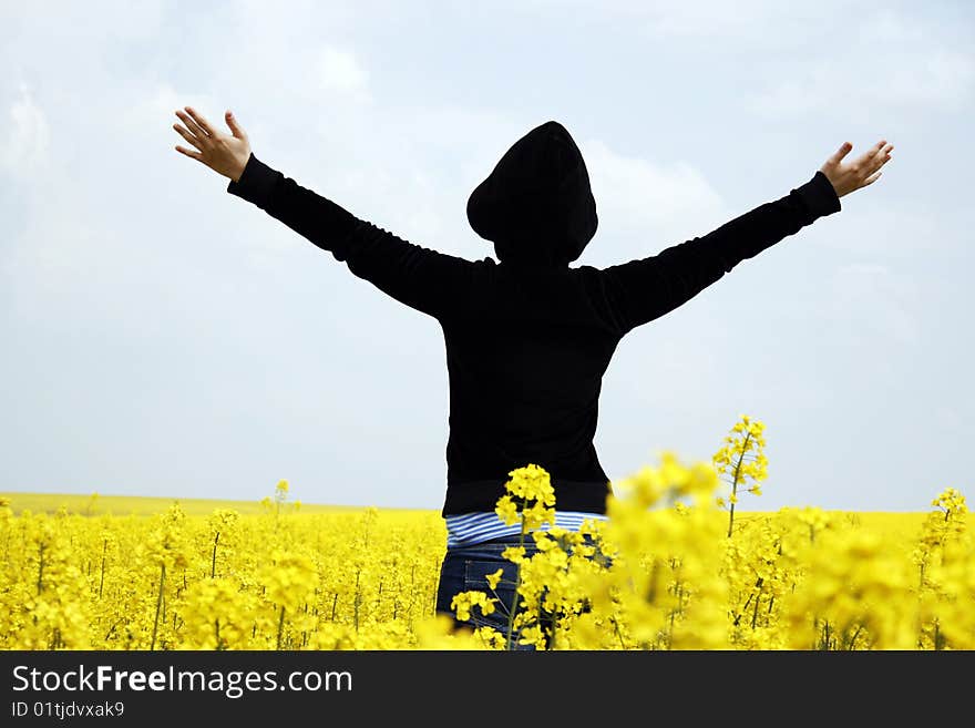 Young girl with hands raised against the sky in a field. Young girl with hands raised against the sky in a field