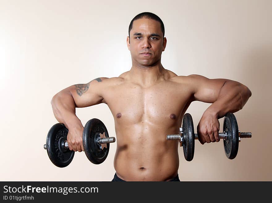 Muscular male body, lifting dumbbells