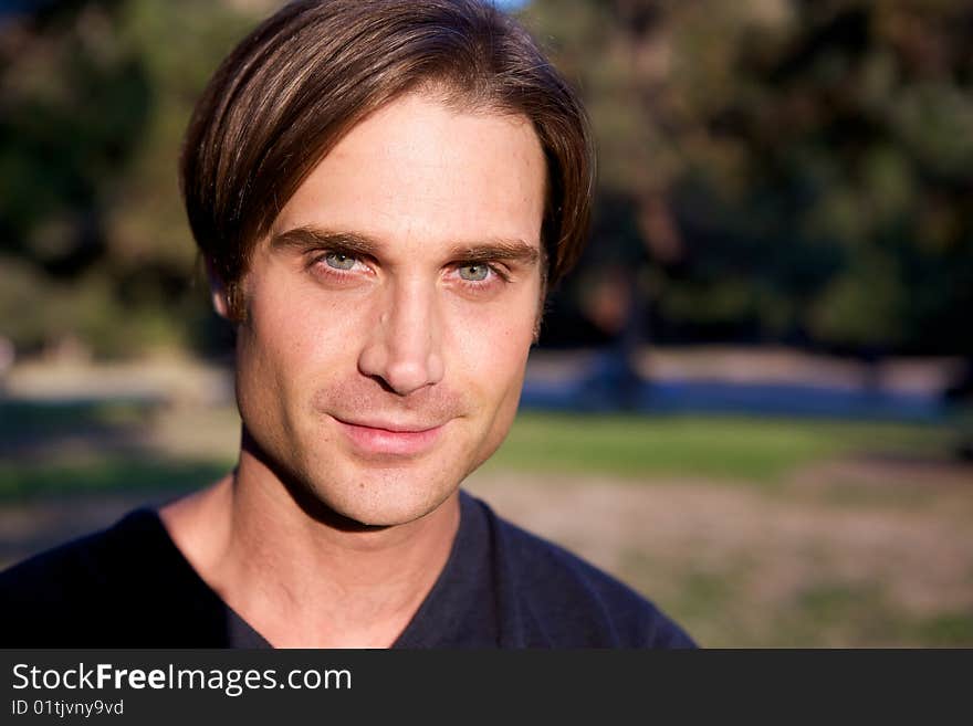 An attractive man in the park with trees. An attractive man in the park with trees