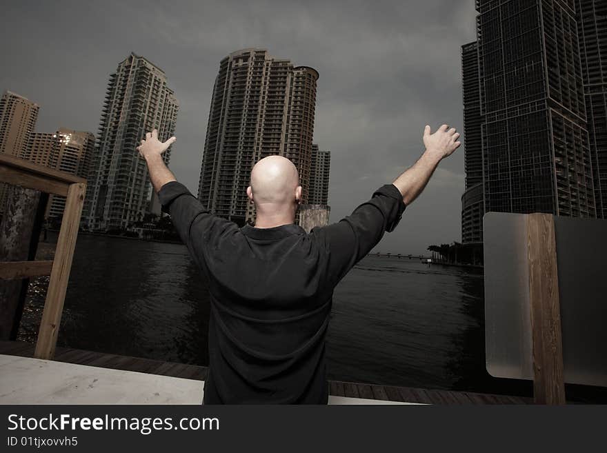 Man with arms extended towards building