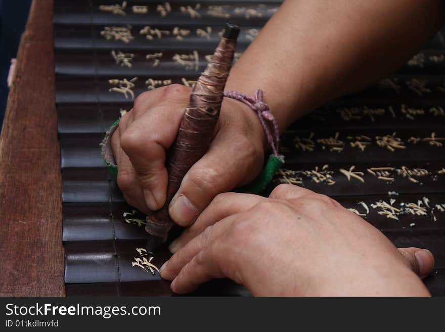 A hand which was carving the characters. A hand which was carving the characters