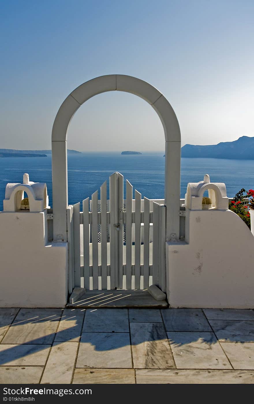 A lovely view of the ocean from a white arched gate. A lovely view of the ocean from a white arched gate