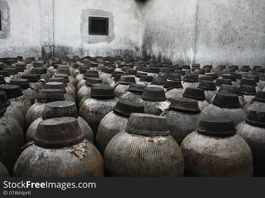 Some ceramic tanks of distilled spirits are on the floor quietly