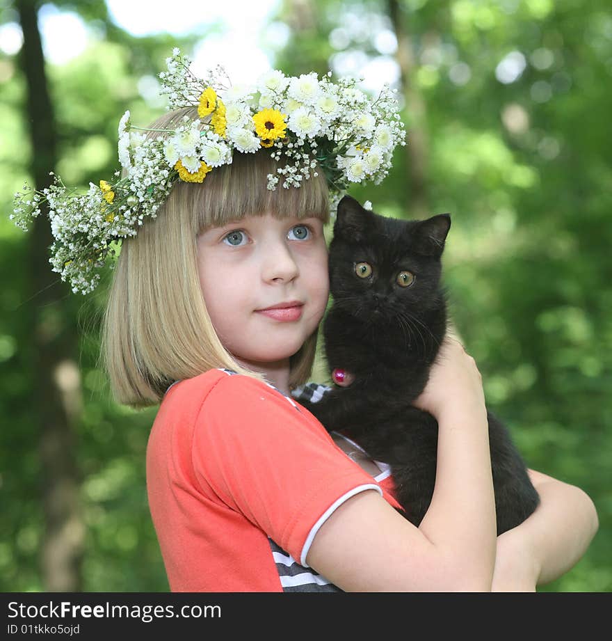 The girl with a black kitten in hands. The girl with a black kitten in hands.