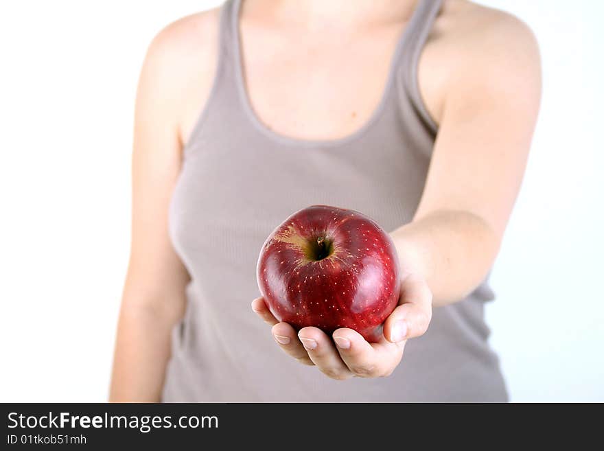 The woman holds an apple in hand. The woman holds an apple in hand