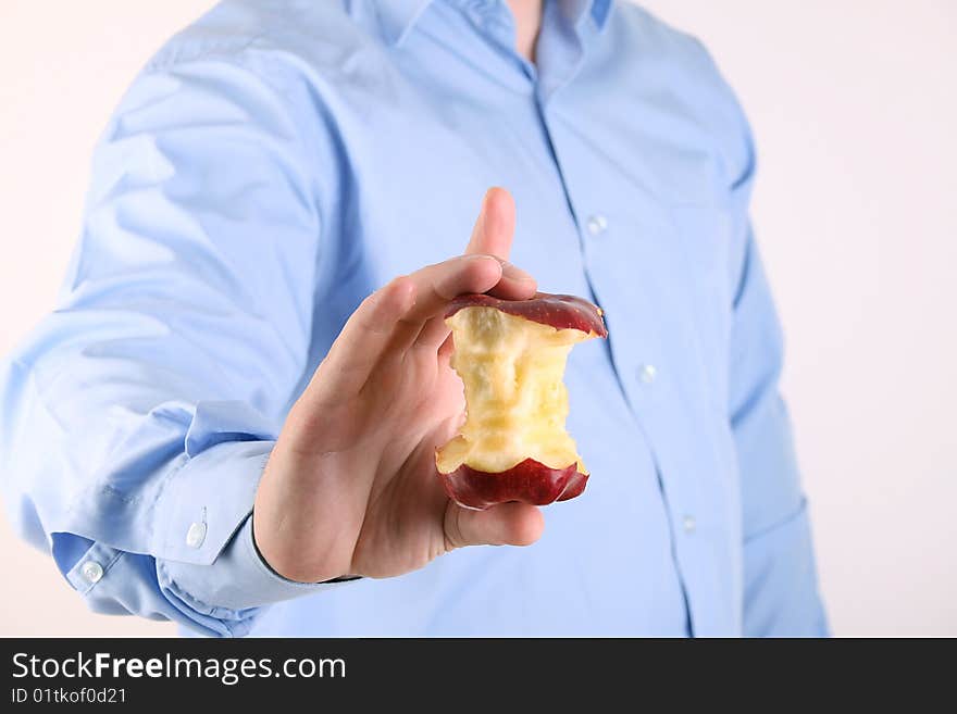 The man holds an apple core in hand