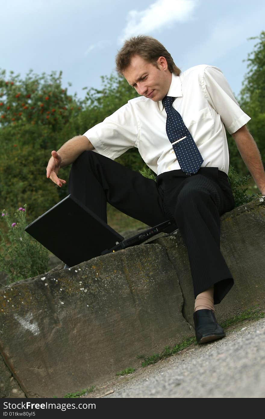 Businessman working with a laptop computer outdoor. Businessman working with a laptop computer outdoor