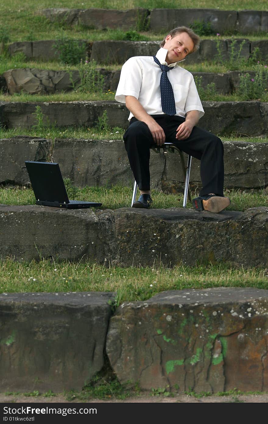 Relaxing businessman sitting on the steps with laptop. Relaxing businessman sitting on the steps with laptop