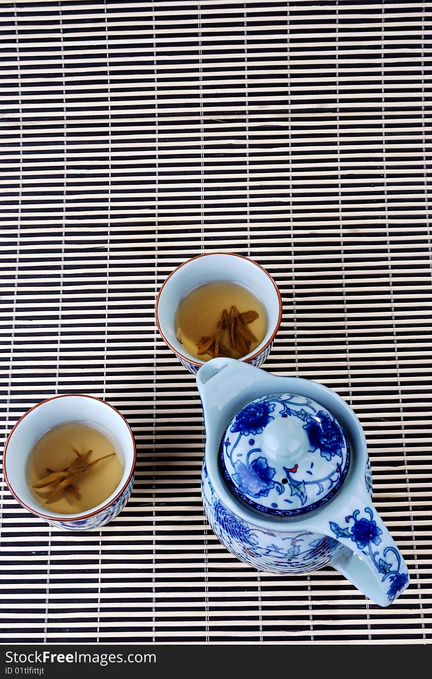 Blue and white porcelain teapot and teacups in the background of bambooã€‚