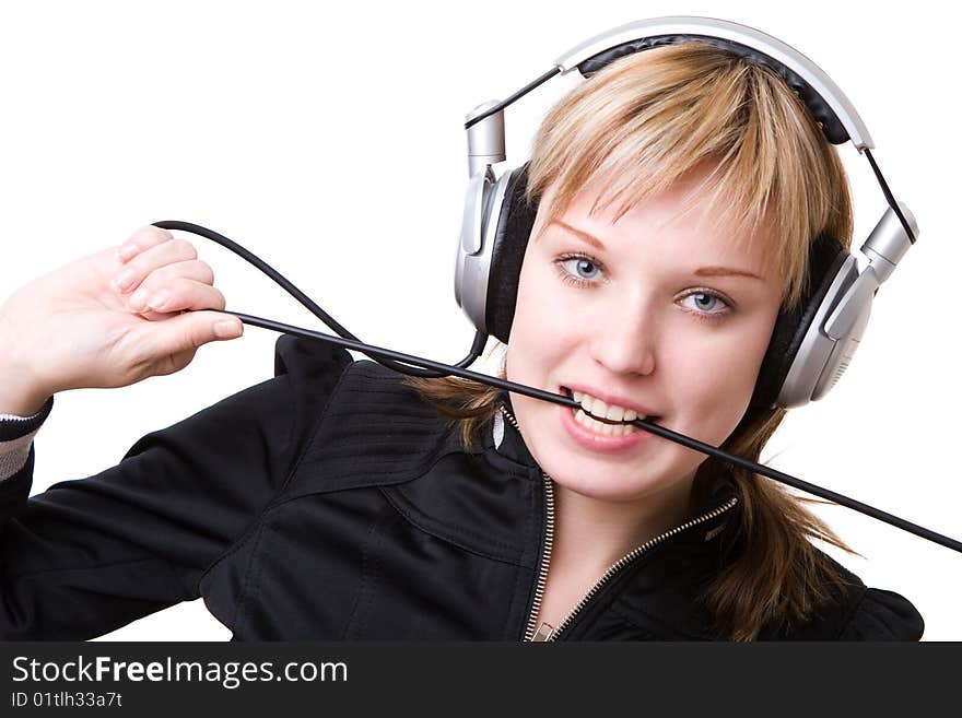 A girl plays with a cable of the earphones listening to the music. A girl plays with a cable of the earphones listening to the music