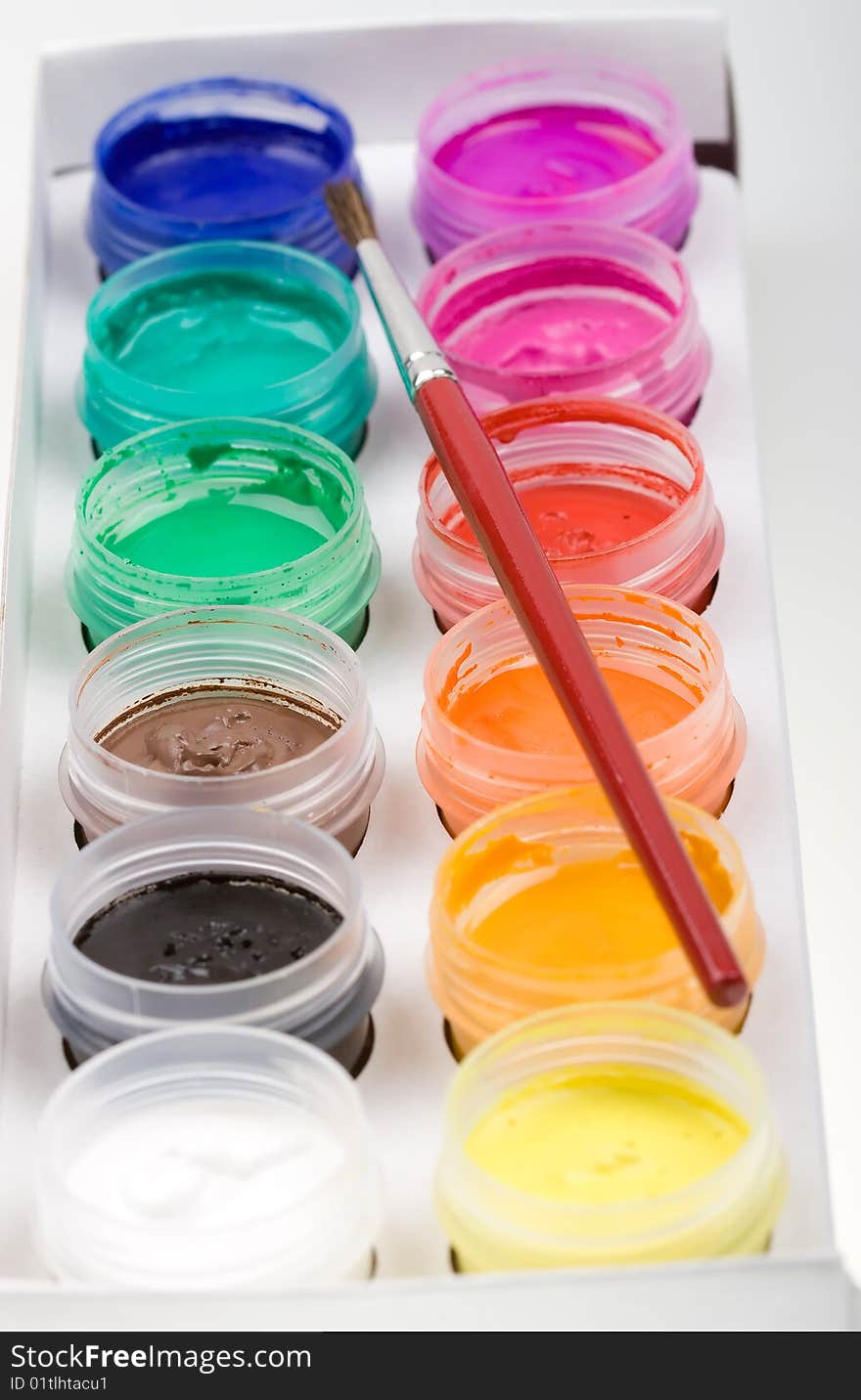 Group of colorful paint cans with brush to background