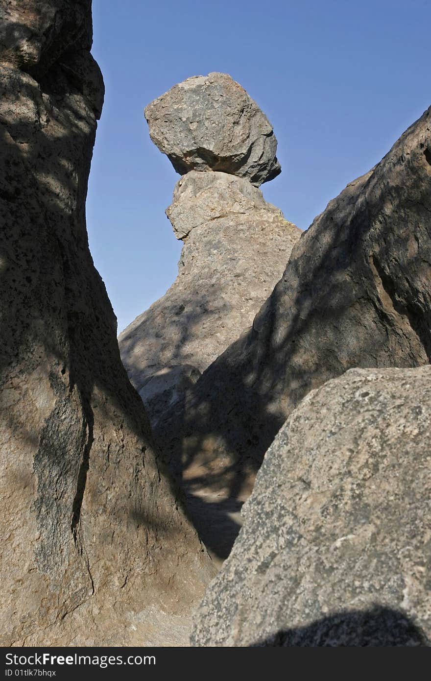 A volcanic boulder perches precariously on a column of rock. A volcanic boulder perches precariously on a column of rock.