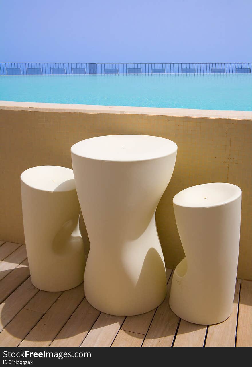 Refreshing swimming pool with simple table and stools. Refreshing swimming pool with simple table and stools